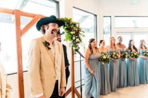 A man in a cowboy hat is standing next to his bridesmaids.
