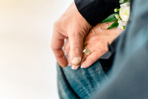 A woman's hand holding a wedding ring.