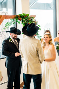 A bride in a cowboy hat and a groom in a cowboy hat.