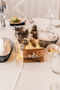 A table setting with pine cones and candles on it.