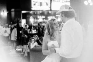 A bride and groom dance in a bar.