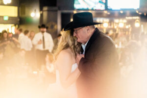 A man in a cowboy hat dances with his father.