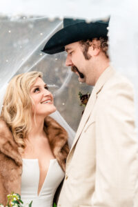 A bride and groom in a cowboy hat.